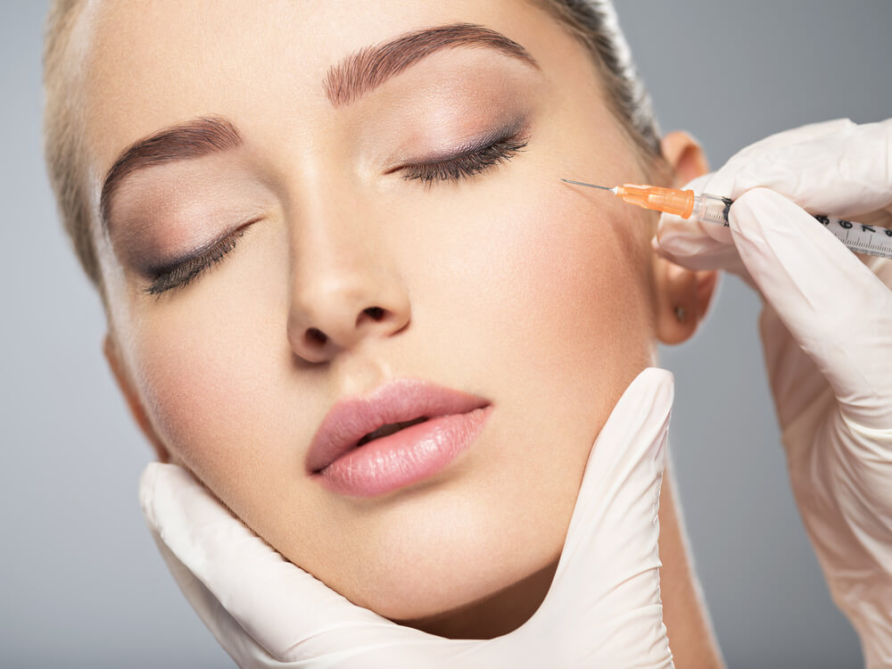 Woman Getting Cosmetic Injection of Botox Near Eyes, Closeup